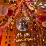 Décoration d'anniversaire élégante dans un style bohème avec des guirlandes et des fleurs.