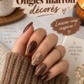 Manucure chic avec des ongles marron décorés, mettant en avant des motifs élégants.